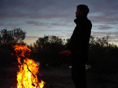 Dan, warming by the camp fire at sunset